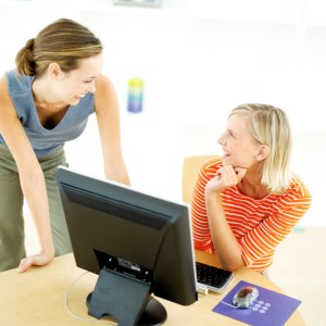 Two Young Women in Front of the Computer Talking